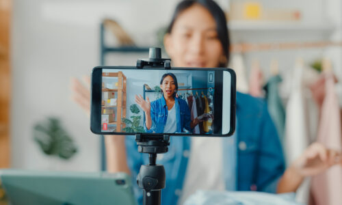 A woman records a video on her phone